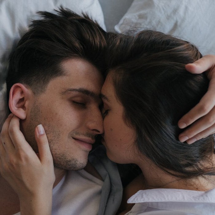 A couple embrace in bed