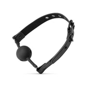 A black silicone ball gag with an adjustable faux leather strap, featuring 9 holes and a rounded ball end.