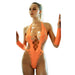 Woman wearing an orange bodystocking with cut-out design, standing in front of a mirror.