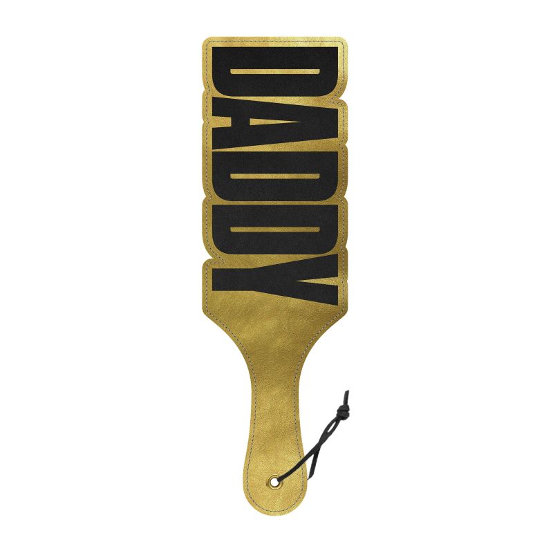 A gold-colored paddle with the word 'DADDY' in bold, capital letters on a shiny surface. The paddle has a handle with a snap button for easy use.